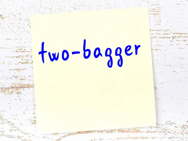 Çift poşetçiyi hatırlatma anlayışı. Tahta duvarda üzerinde yazı olan sarı yapışkan kağıt.