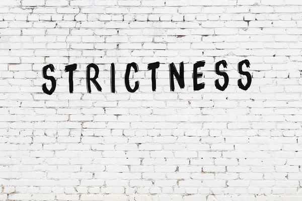 Üzerinde yazı olan beyaz tuğla duvar. Elle yazılmış siyah boya.