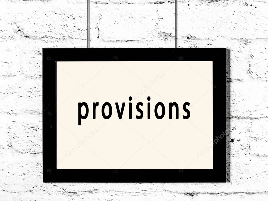 Black wooden frame with inscription provisions hanging on white brick wall 