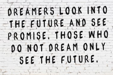 Üzerinde mantıklı alıntıların yazılı olduğu siyah boyanmış beyaz tuğla duvar.