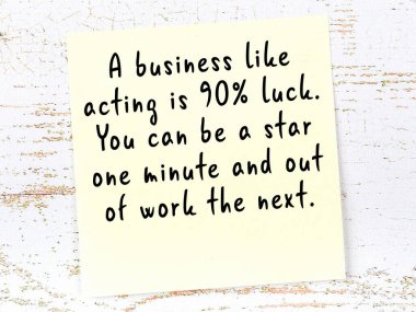 Sarı yapışkan not, ahşap duvarda el yazısıyla yazılmış zekice bir alıntıyla.