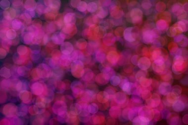 Çember şeklindeki bokeh noktalarıyla odaklanmış mor ve kırmızı soyut arkaplan