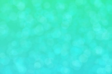 Çember şeklindeki bokeh noktalarıyla mavi ve yeşil soyut odaklanmış arkaplan