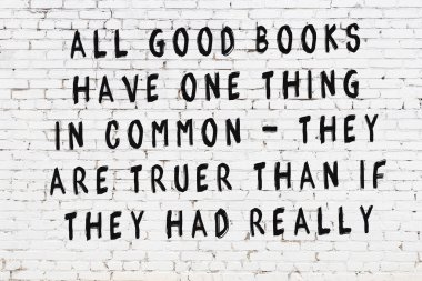 Beyaz tuğla duvar ve bilgece alıntıların yazılı olduğu siyah yazı.