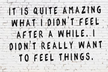 Beyaz tuğla duvar ve bilgece alıntıların yazılı olduğu siyah yazı.