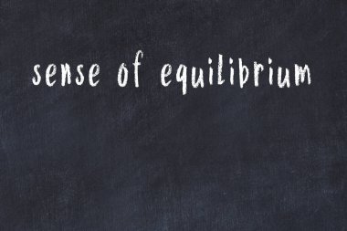 Üzerinde el yazısıyla yazılmış denge duygusu olan üniversite yazı tahtası.