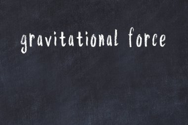 Tebeşir elle yazılmış yazıtlar siyah masanın üzerinde yer çekimi kuvveti