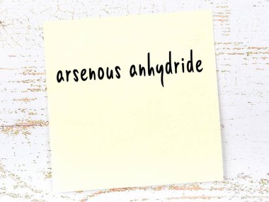 Arsenöz anhidratı hatırlatma kavramı. Tahta duvarda üzerinde yazı olan sarı yapışkan kağıt.