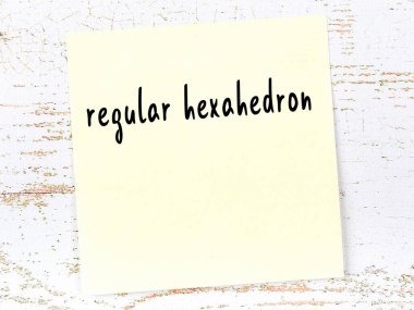 Normal altıyüzlü hakkında hatırlatma kavramı. Tahta duvarda üzerinde yazı olan sarı yapışkan kağıt.