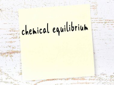 Kimyasal dengeyi hatırlatma kavramı. Tahta duvarda üzerinde yazı olan sarı yapışkan kağıt.