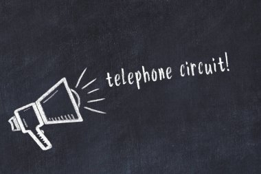 Hoparlörün tebeşir çizimi ve siyah masanın üzerine el yazısıyla yazılmış telefon devresi