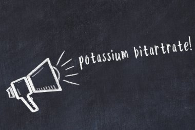 Hoparlörün tebeşir çizimi ve siyah masanın üzerine el yazısıyla yazılmış potasyum bitarat.