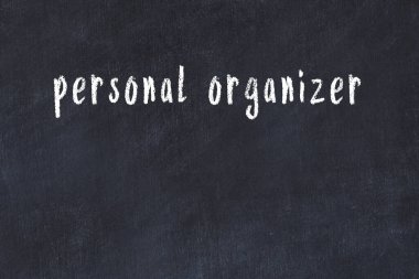 Tebeşir el yazısıyla yazılmış kişisel düzenleyici siyah masada.