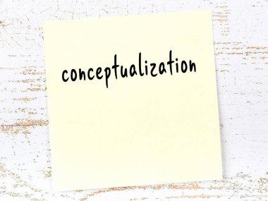 Kavramsallaştırmayı hatırlatma kavramı. Tahta duvarda üzerinde yazı olan sarı yapışkan kağıt.