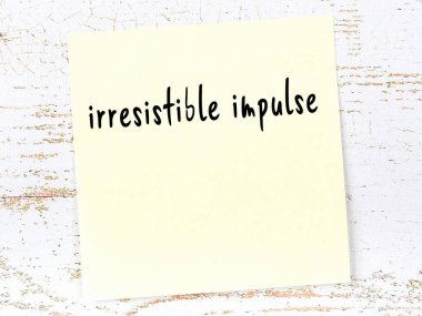 Tahta duvardaki sarı yapışkan notta el yazısıyla yazılmış karşı konulamaz bir dürtü var.