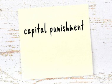 İdam cezasını hatırlatma kavramı. Tahta duvarda üzerinde yazı olan sarı yapışkan kağıt.