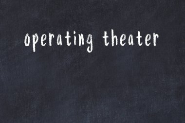 Tebeşir el yazısıyla yazılmış ameliyathane siyah masada.