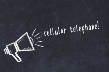Hoparlörün tebeşir çizimi ve siyah masanın üzerine el yazısıyla yazılmış cep telefonu.