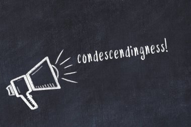 Hoparlörün tebeşir çizimi ve siyah masanın üzerine el yazısıyla yazılmış küçümseme.