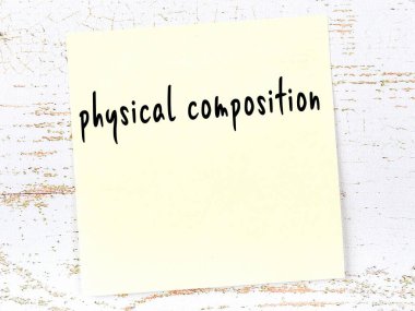 Tahta duvardaki sarı yapışkan notta elle yazılmış fiziksel kompozisyon var.