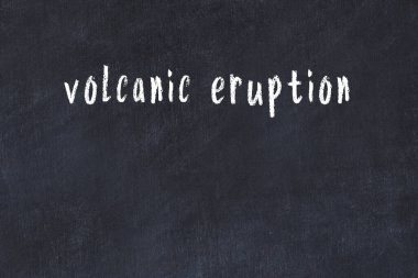 Siyah masanın üzerinde el yazısıyla yazılmış volkanik patlama.