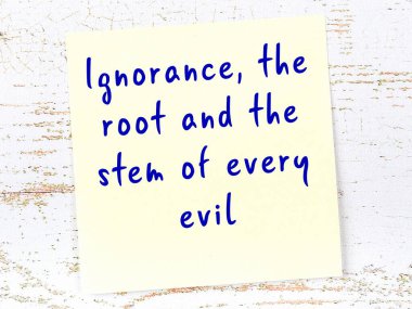 Tahta duvarda el yazısı motivasyon alıntısı olan sarı yapışkan not