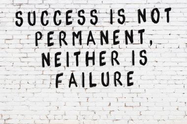 Üzerinde mantıklı alıntıların yazılı olduğu siyah boyanmış beyaz tuğla duvar.