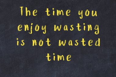 Siyah masa üzerine tebeşirle yazılmış zekice bir söz.