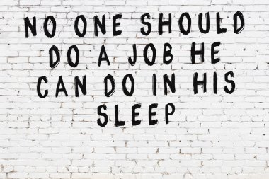 Beyaz tuğla duvar ve bilgece alıntıların yazılı olduğu siyah yazı.