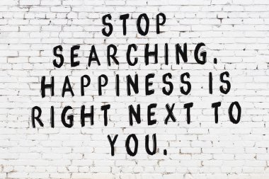 Beyaz tuğla duvar ve bilgece alıntıların yazılı olduğu siyah yazı.