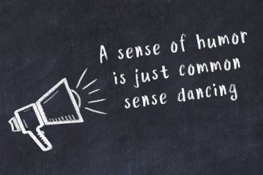 Bir hoparlörün tebeşir çizimi ve siyah karatahtaya el yazısıyla yazılmış alıntılar