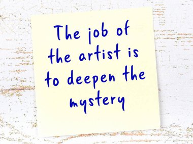 Tahta duvarda asılı sarı yapışkan nota elle yazılmış bilgece bir alıntı.