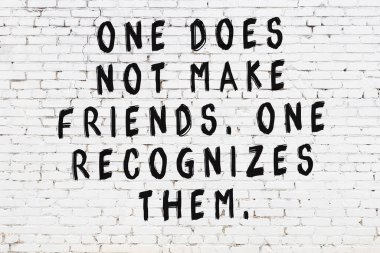 Üzerinde mantıklı alıntıların yazılı olduğu siyah boyanmış beyaz tuğla duvar.