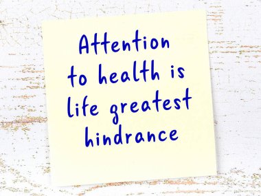 Tahta duvarda el yazısı motivasyon alıntısı olan sarı yapışkan not