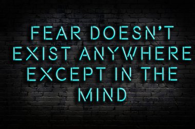 Tuğla duvardaki ışıklı neon tabela olarak bilgece alıntı