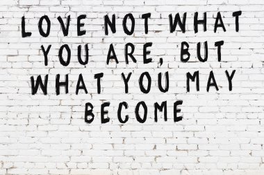 Beyaz tuğla duvar ve bilgece alıntıların yazılı olduğu siyah yazı.