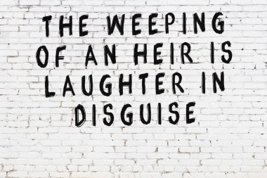 Beyaz tuğla duvara zekice alıntılar yazılı siyah bir yazı.