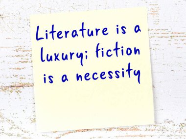 Sarı yapışkan not, ahşap duvarda el yazısıyla yazılmış zekice bir alıntıyla.