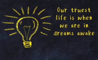 Bilgece bir alıntı ve siyah karatahtaya bir ampul çizimi