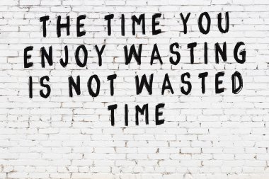 Beyaz tuğla duvar ve bilgece alıntıların yazılı olduğu siyah yazı.