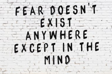 Üzerinde mantıklı alıntıların yazılı olduğu siyah boyanmış beyaz tuğla duvar.