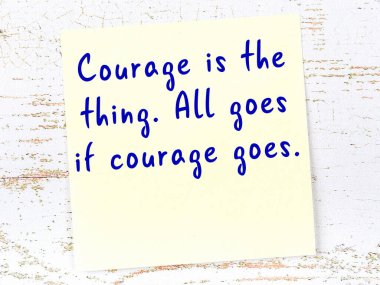 Sarı yapışkan not, ahşap duvarda el yazısıyla yazılmış zekice bir alıntıyla.