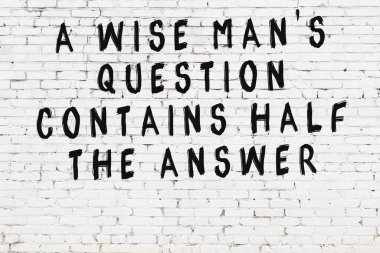 Üzerinde mantıklı alıntıların yazılı olduğu siyah boyanmış beyaz tuğla duvar.