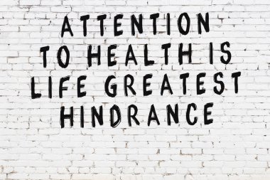 Beyaz tuğla duvar ve bilgece alıntıların yazılı olduğu siyah yazı.