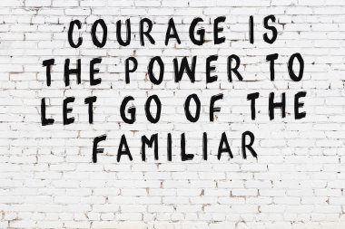 Üzerinde mantıklı alıntıların yazılı olduğu siyah boyanmış beyaz tuğla duvar.