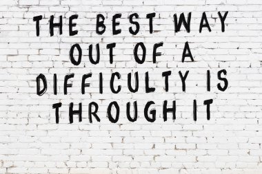 Üzerinde mantıklı alıntıların yazılı olduğu siyah boyanmış beyaz tuğla duvar.