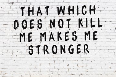 Beyaz tuğla duvar ve bilgece alıntıların yazılı olduğu siyah yazı.