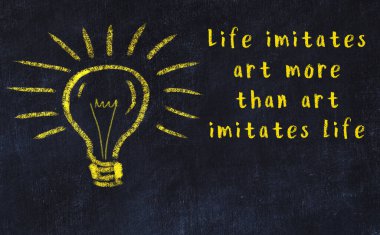 Bir karatahtaya ve bir ampul çizimine elle yazılmış akıllı bir alıntı.