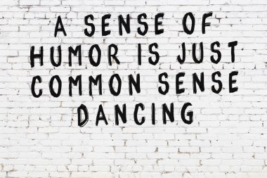 Beyaz tuğla duvar ve bilgece alıntıların yazılı olduğu siyah yazı.