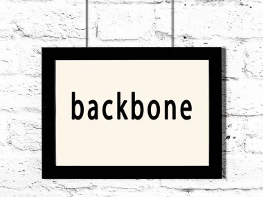 Beyaz tuğla duvarda asılı siyah ahşap iskelet. 